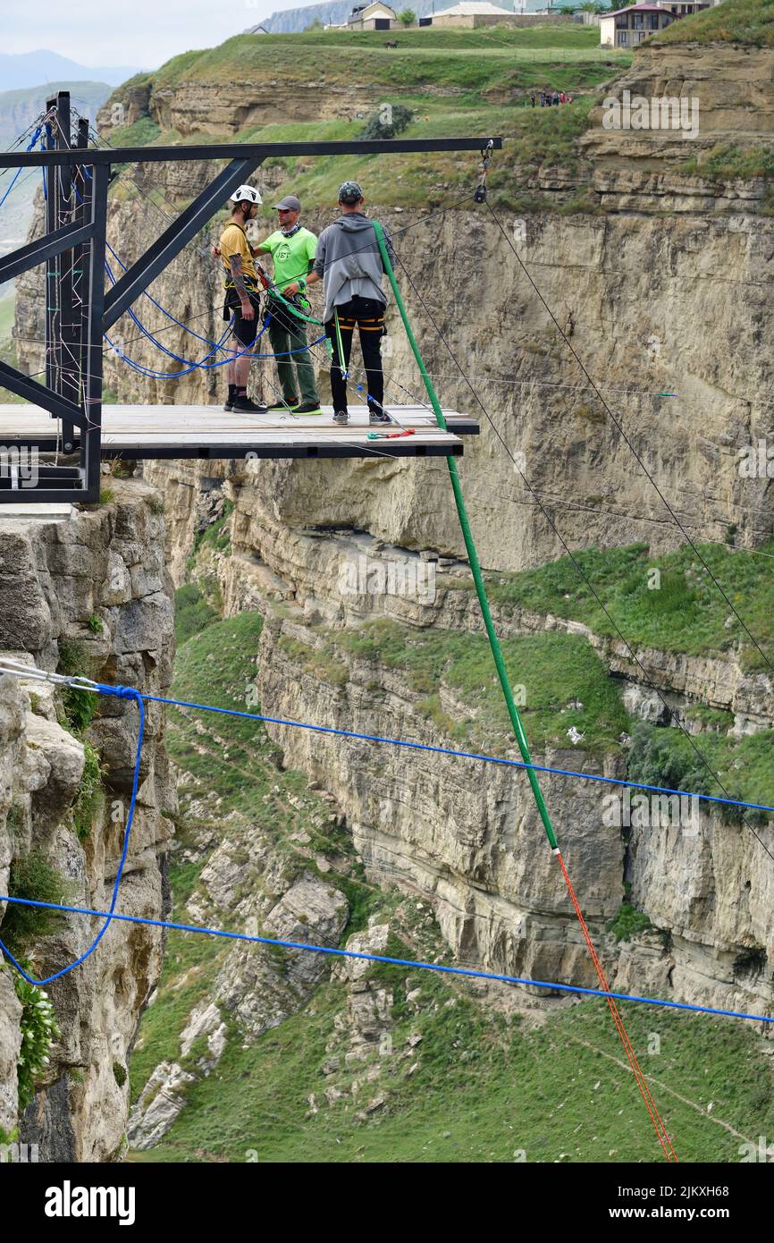 Dagestan, Russia - 21 July, 2022: Brave man prepares to extreme jump from platform above the canyon of Khunzakh and the Tobot Waterfall. Bungee in the Stock Photo