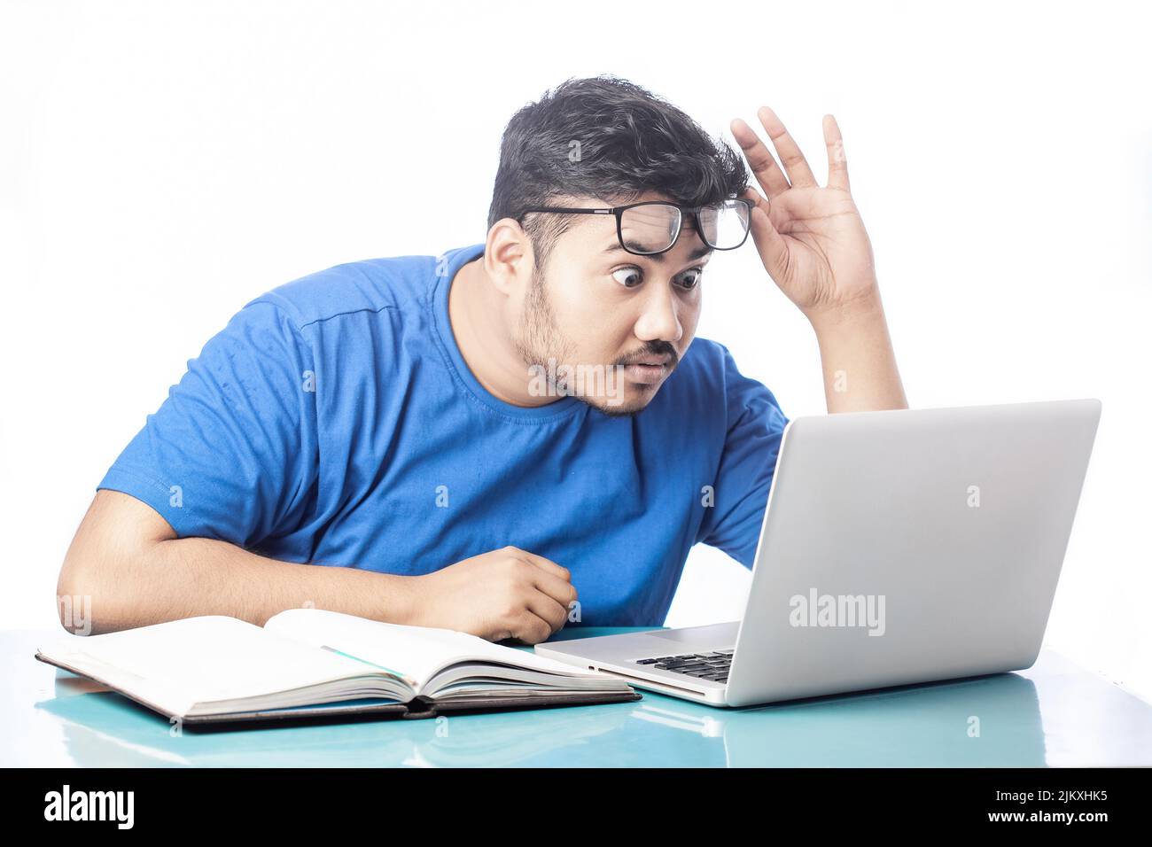 shocked man looking at laptop screen by taking off eyeglass Stock Photo