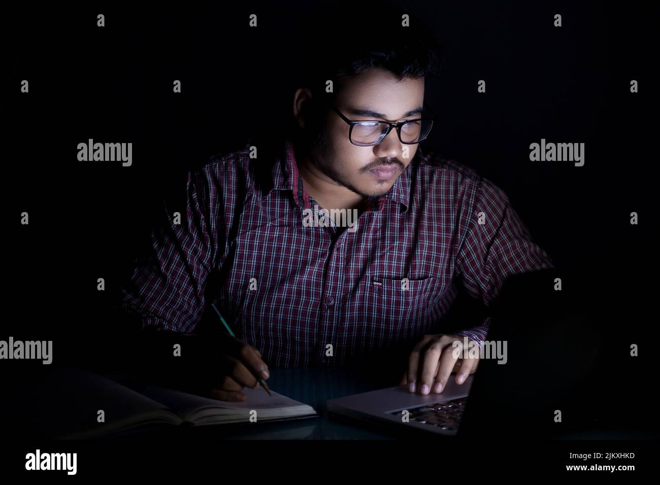 dedicated student studying online course at late night using laptop Stock Photo