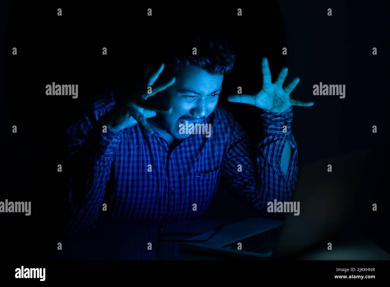 business man yelling or screaming loudly looking at laptop screen at