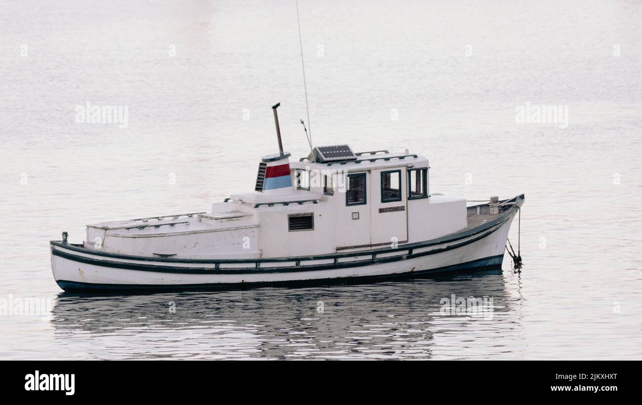 A fishing boat with the reflection in the water Stock Photo - Alamy