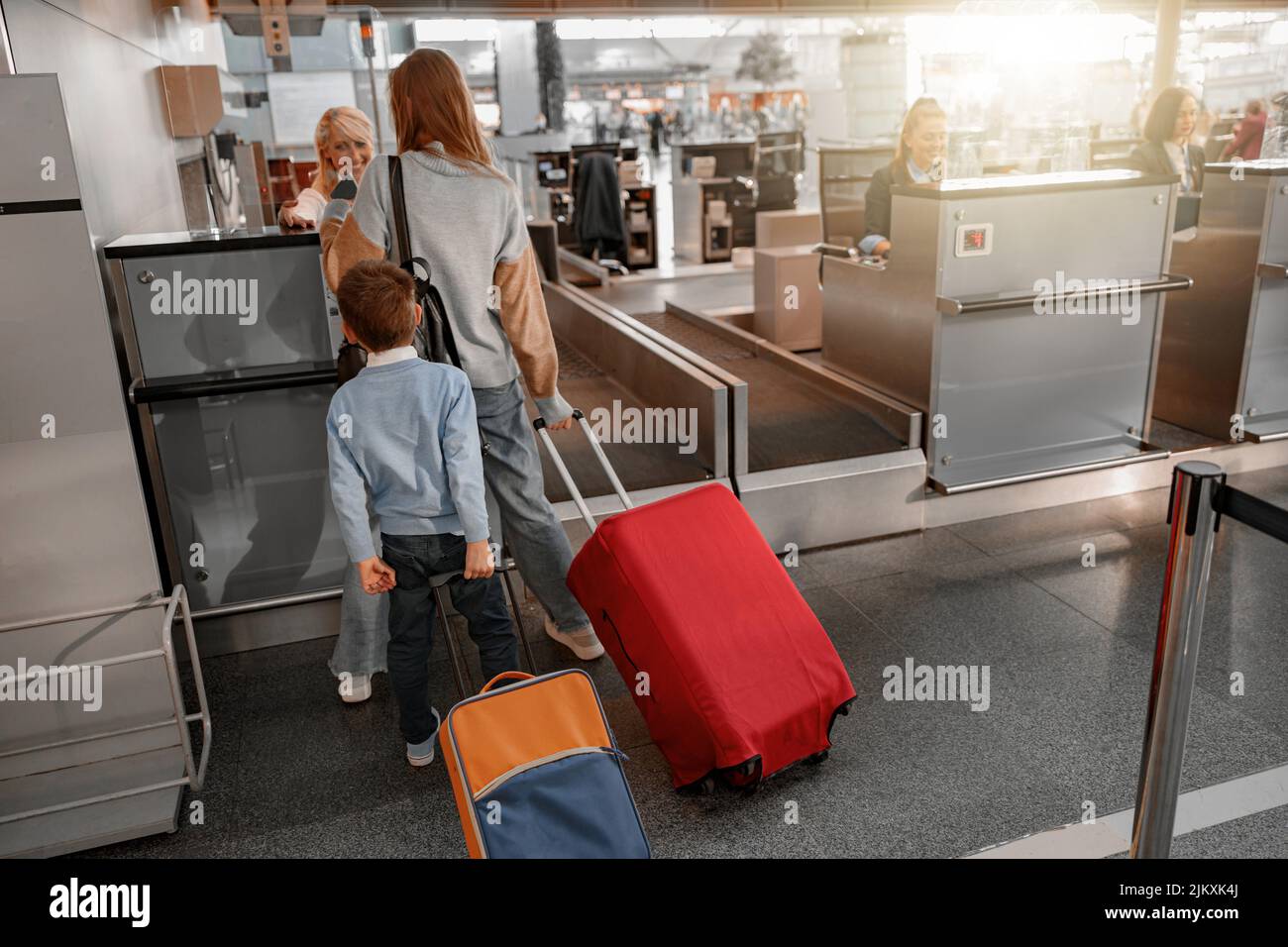Mom and son holding suitcases and going through passport control Stock Photo