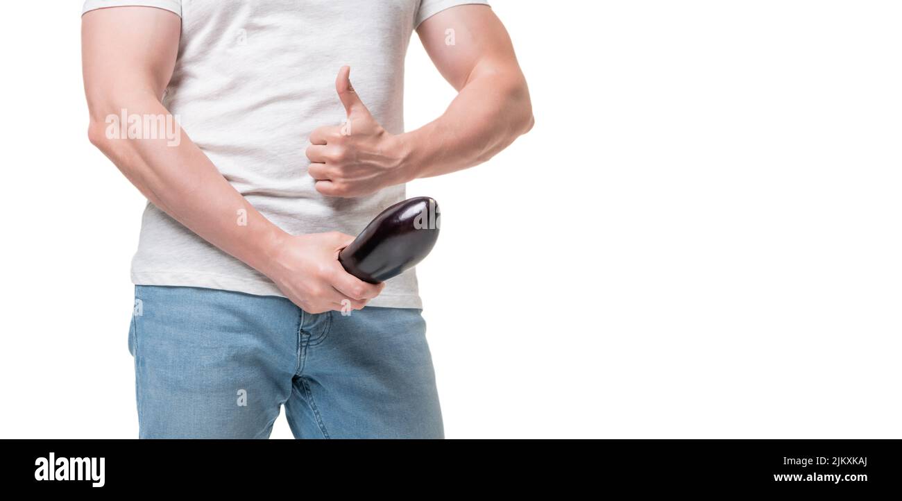 Guy crop view giving thumb holding eggplant at crotch level imitating erect penis, copy space Stock Photo