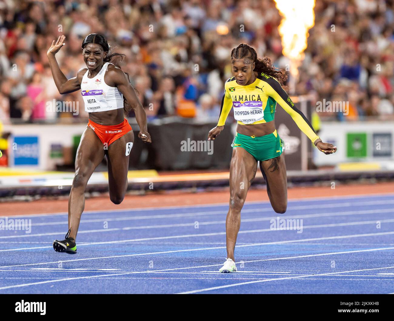 3rd August 2022; Alexander Stadium, Birmingham, Midlands, England: Day 6 of the 2022 Commonwealth Games: Elaine Thompson-Herah (JAM) crossing the finish line to win the Gold Medal in the Women's 100m Final in 10.95s alongside Daryll Neita (ENG) finishing in third place to win the Bronze Medal in 11.07sec Stock Photo