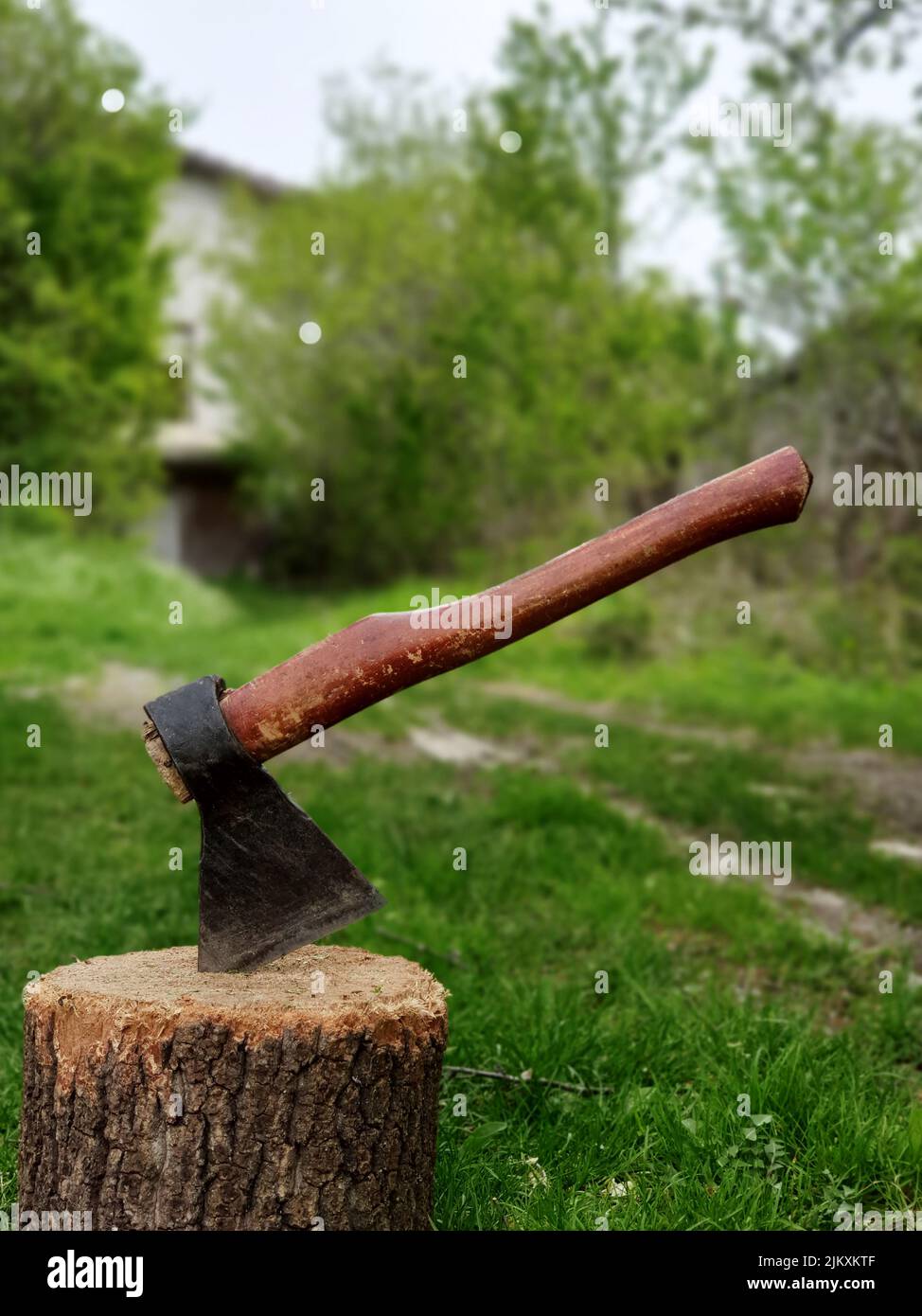 Stuck axe in a log in backyard of a villa Stock Photo
