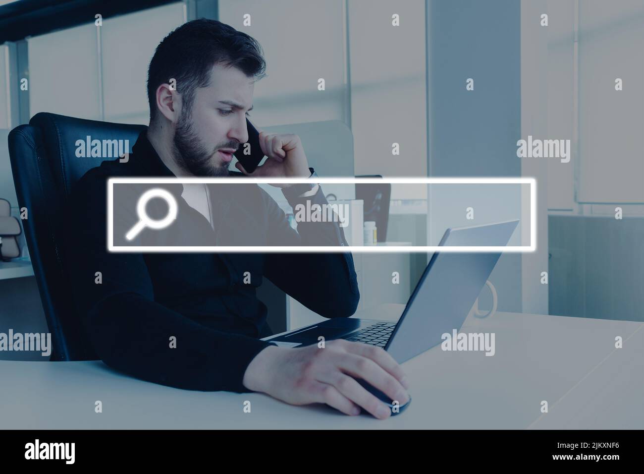 A Young male working on a laptop in the office with a visual screen ...