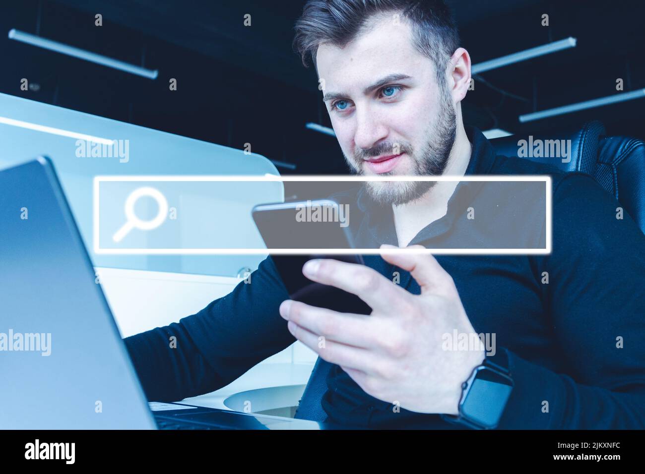 A Young male working on a laptop in the office with a visual screen ...