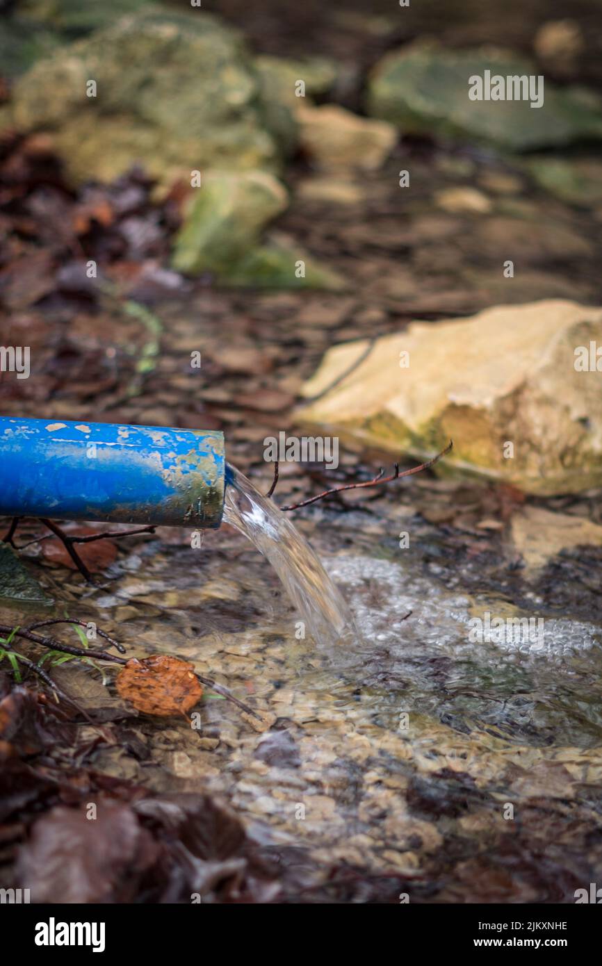 A vertical shot of water flowing out from the pipe Stock Photo Alamy