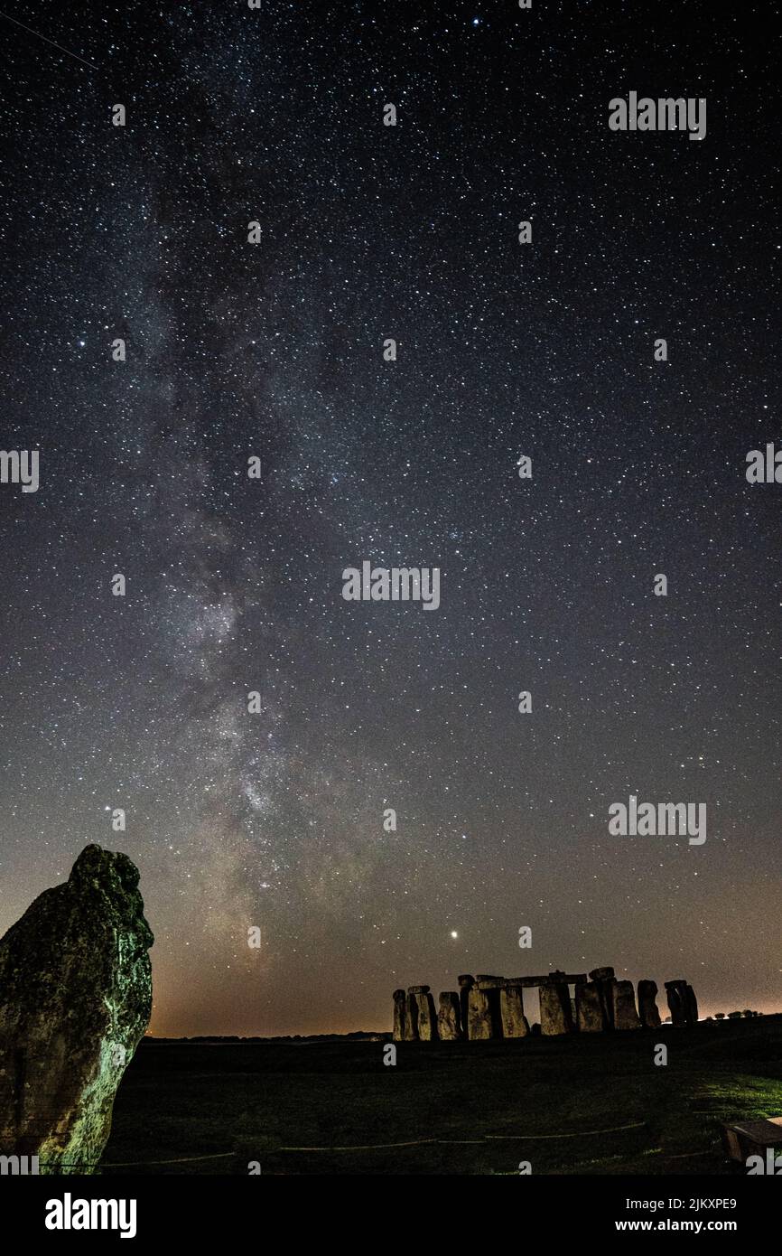 A vertical shot of the Stonehenge and the beautiful Milky Way in the background in Wiltshire, The UK Stock Photo