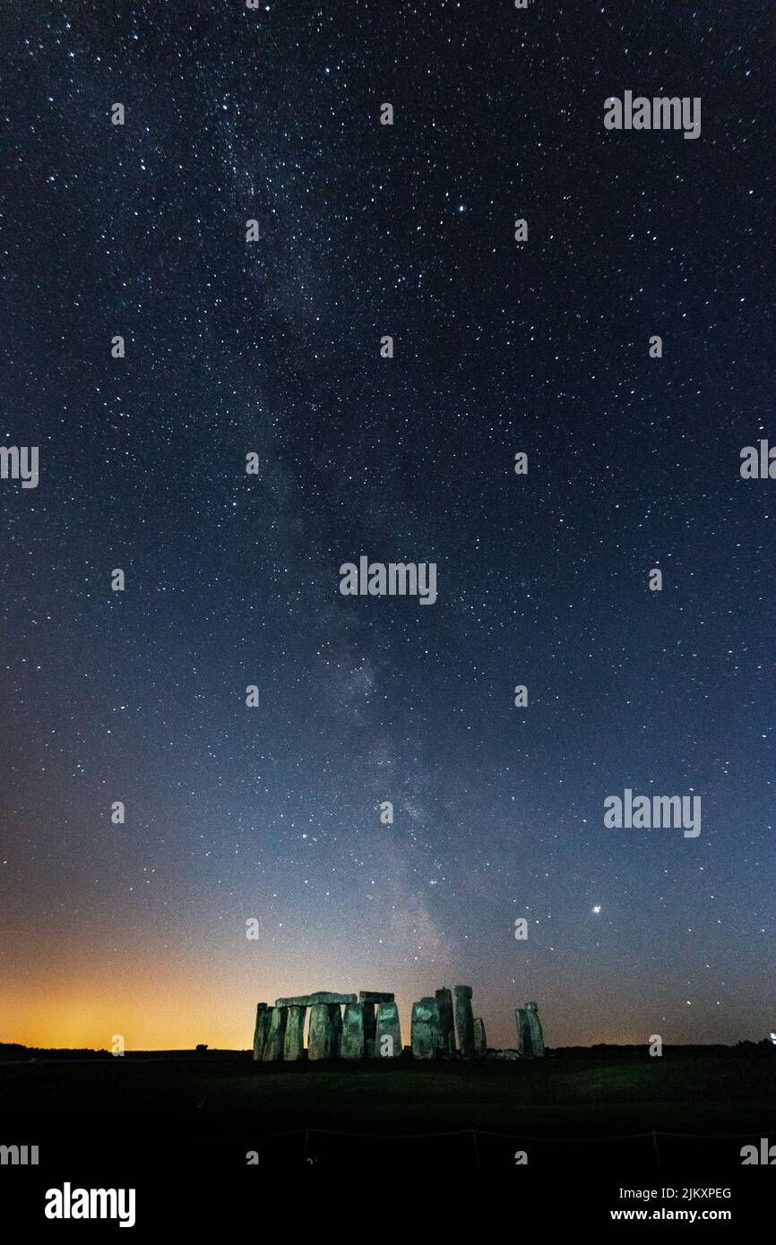 A vertical shot of the Stonehenge and the beautiful Milky Way in the background in Wiltshire, The UK Stock Photo