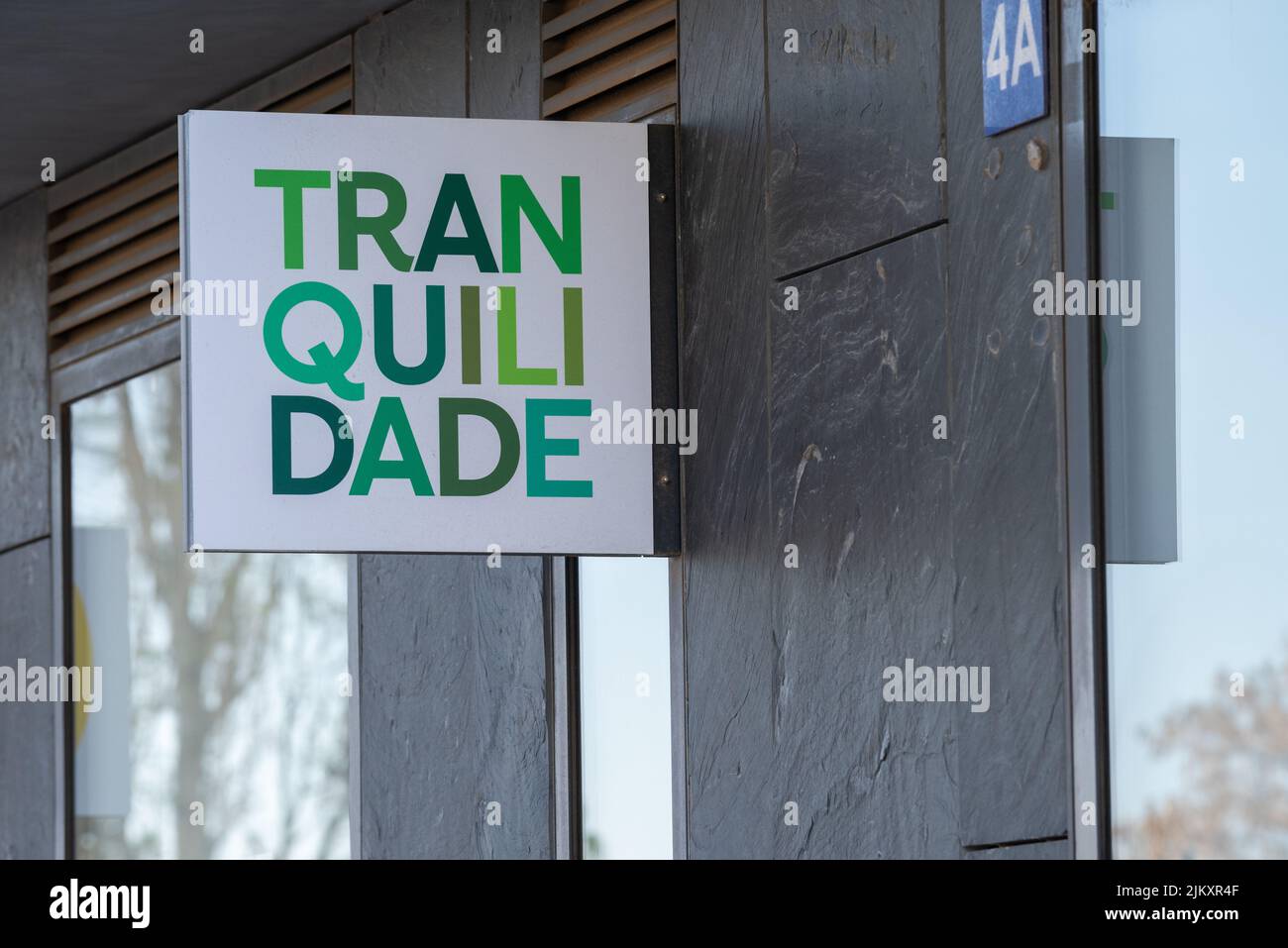 A green sign for the insurance company Tranquilidade in Lisbon, Portugal Stock Photo