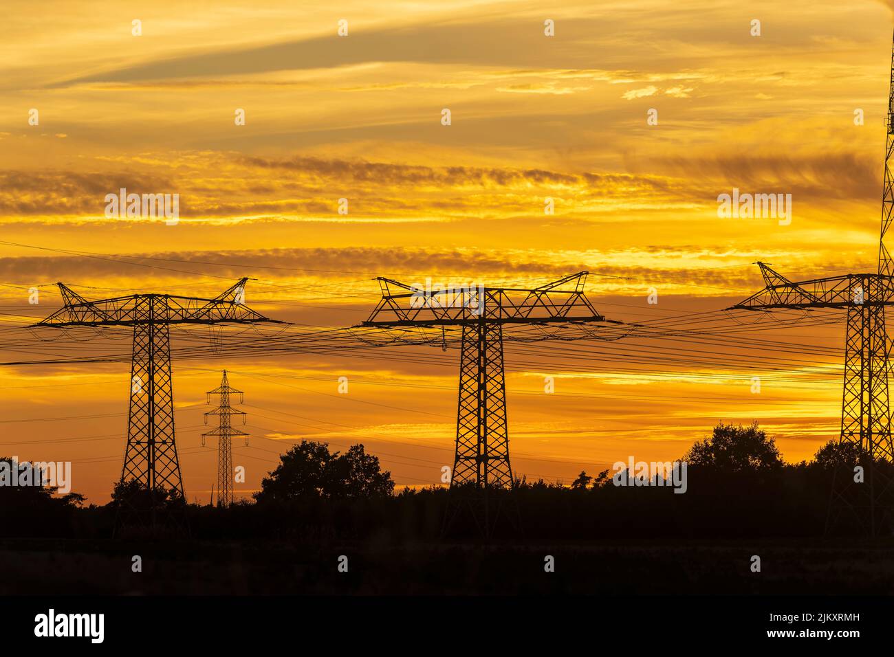 Power poles in Germany at sunset Stock Photo