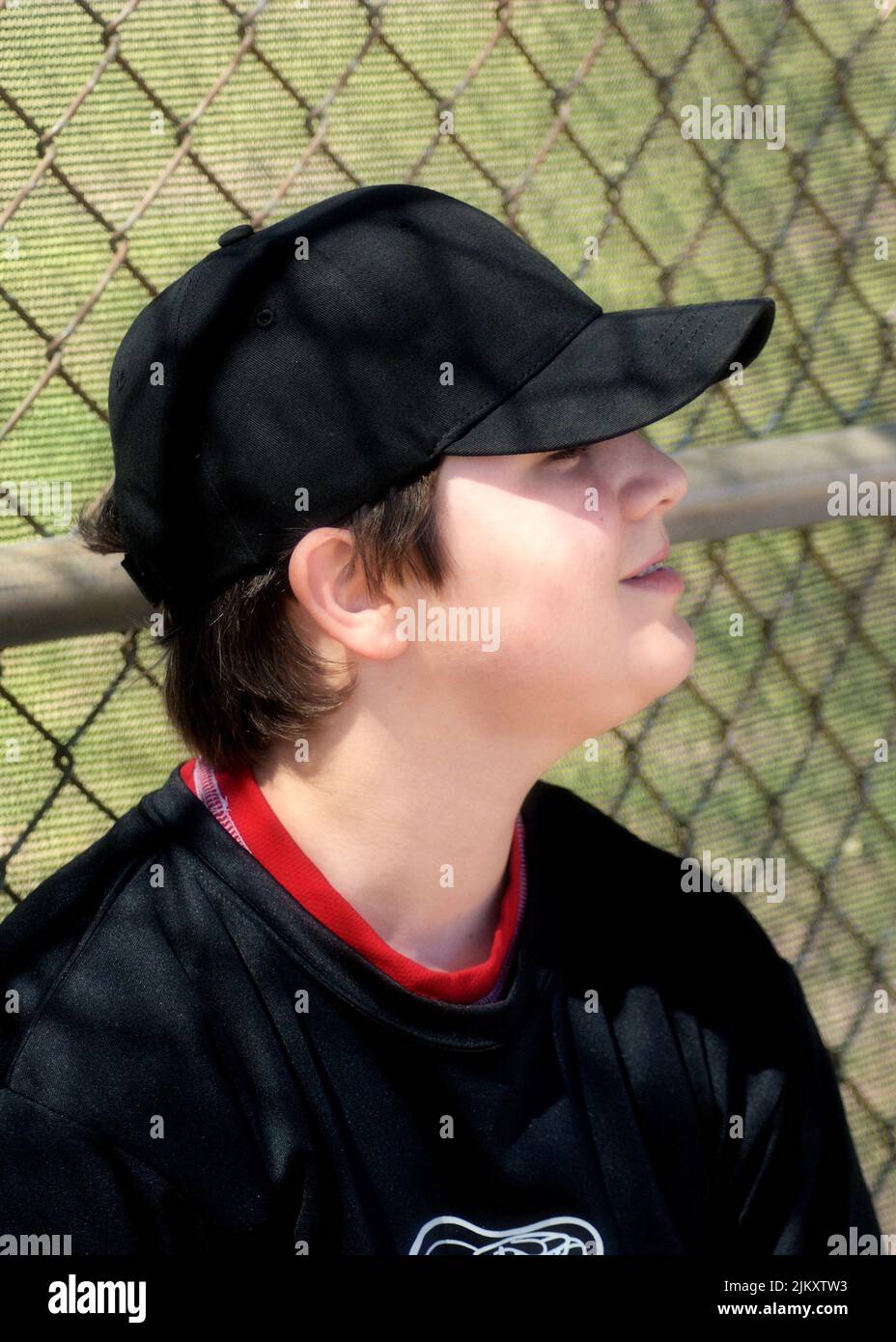 Young, relaxed baseball player enjoying a calm moment in the dugout. Stock Photo