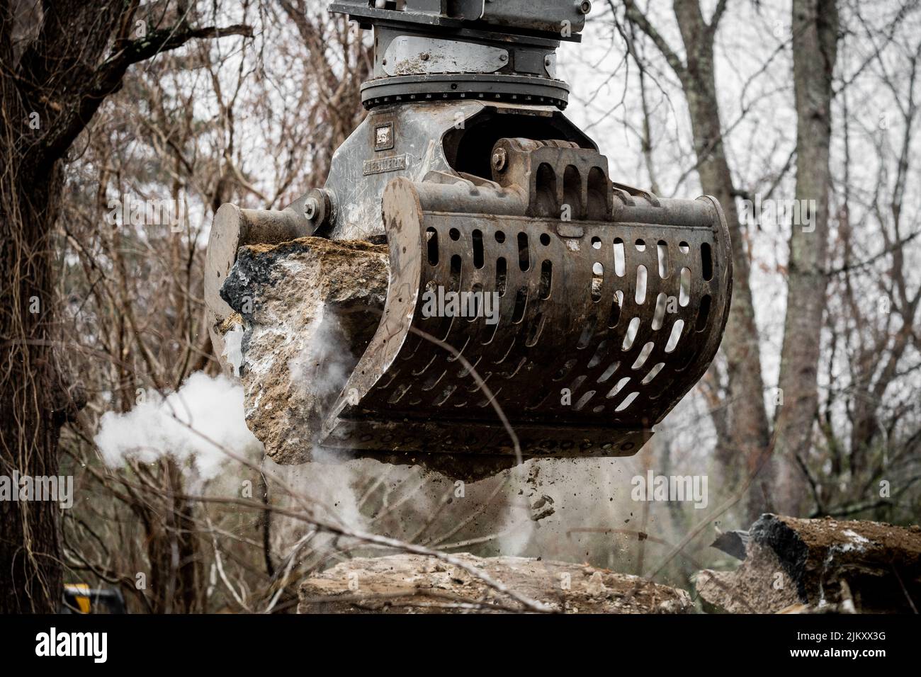 A beautiful shot of heavy Excavator attachment during demolition in a forest Stock Photo