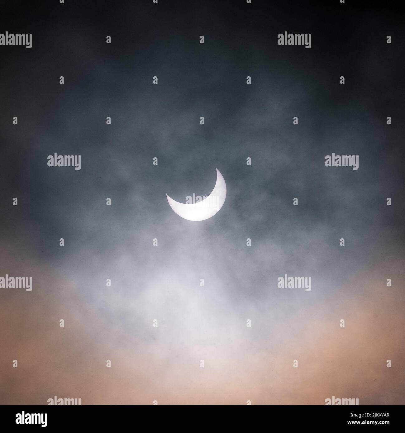 A beautiful shot of the moon in a dark foggy sky at night time Stock Photo
