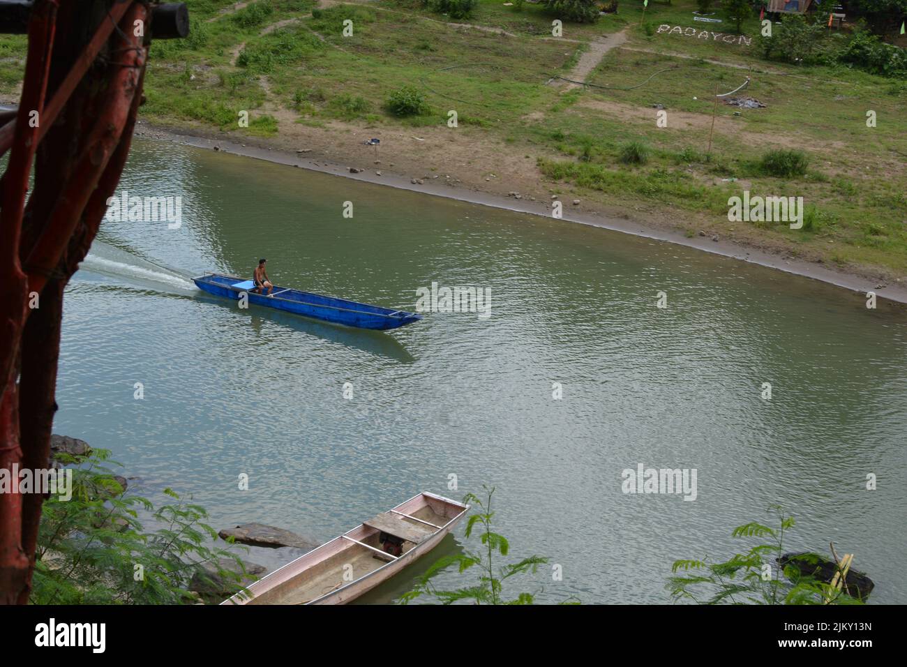 A small blue boat travelling down the Wawa River, Rizal, Philippines Stock Photo