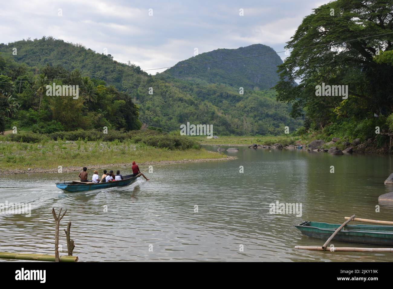 A scenic shot of several people travelling down the Wawa River, Rizal, Philippines on a blue boat Stock Photo