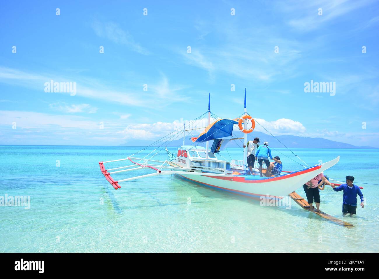 People getting out of motor boat at a beautiful beach in Romblon, Philippines Stock Photo