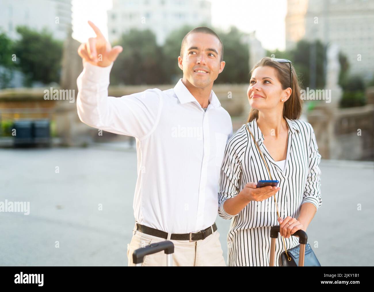 Tourist couple pointing at sights while walking around city Stock Photo ...