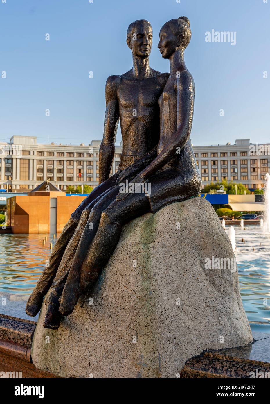 Statue depicting Kazakh man and woman sitting on the stone near fountain in central Nur-Sultan, Astana, Kazakhstan Stock Photo