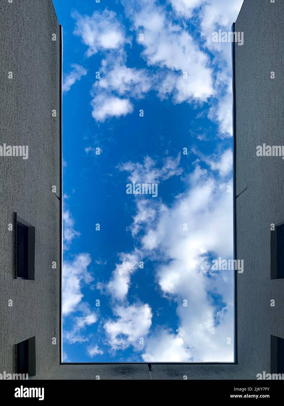 A low angle shot of a building under a blue sky with clouds Stock Photo ...