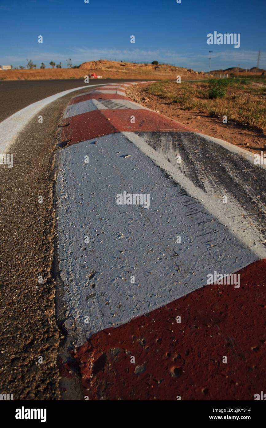 A vertical shot of curbstones at a racetrack with tire skid marks Stock Photo