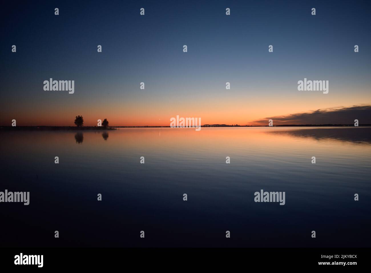 A mesmerizing view of trees with reflection in a lake during susnet in ...