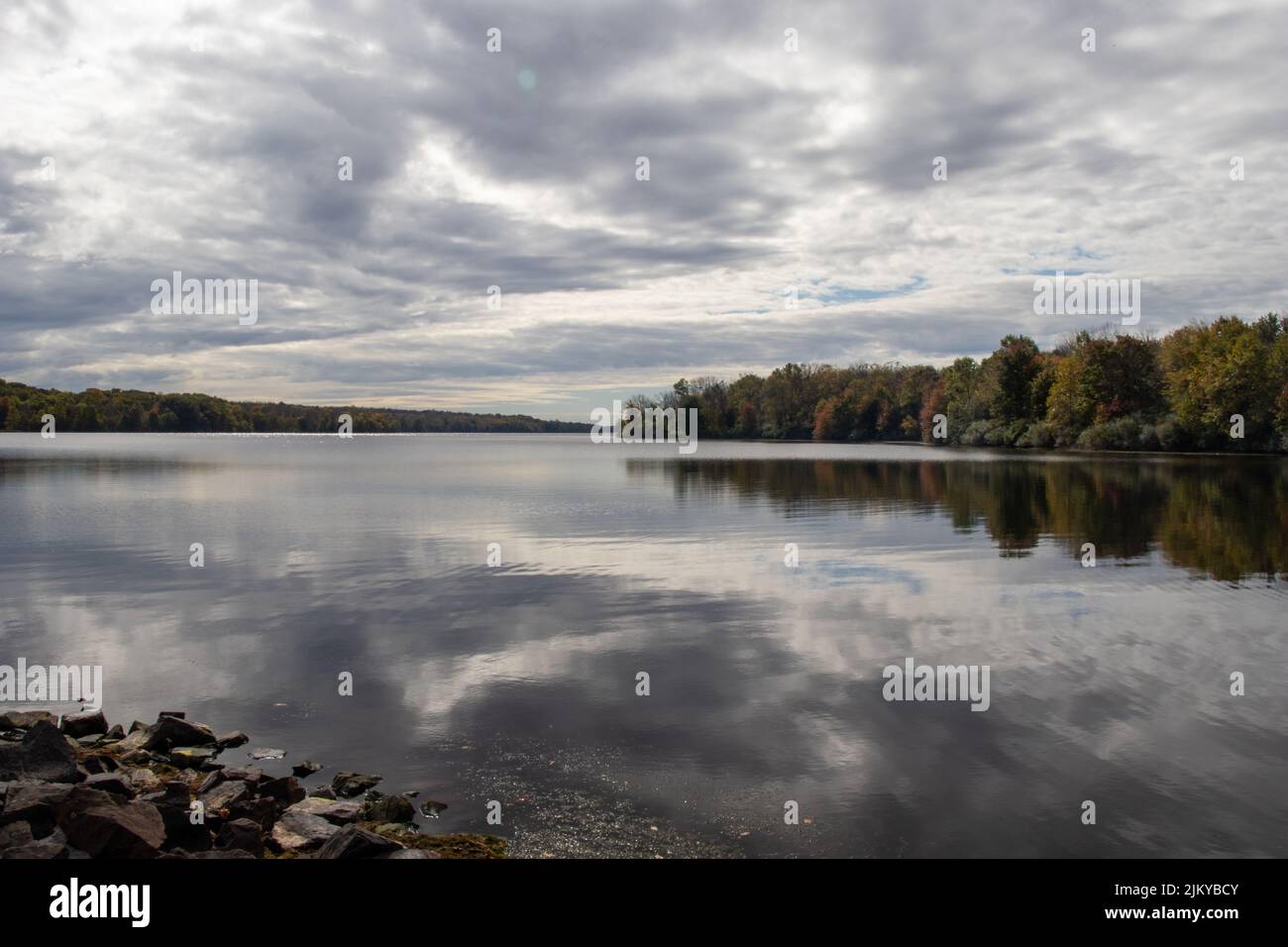 A mesmerizing view of autumn trees with reflection in the lake under ...