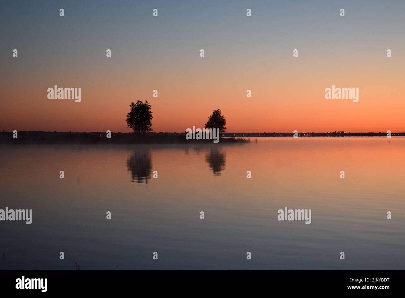 A mesmerizing view of trees with reflection in a lake during susnet in ...