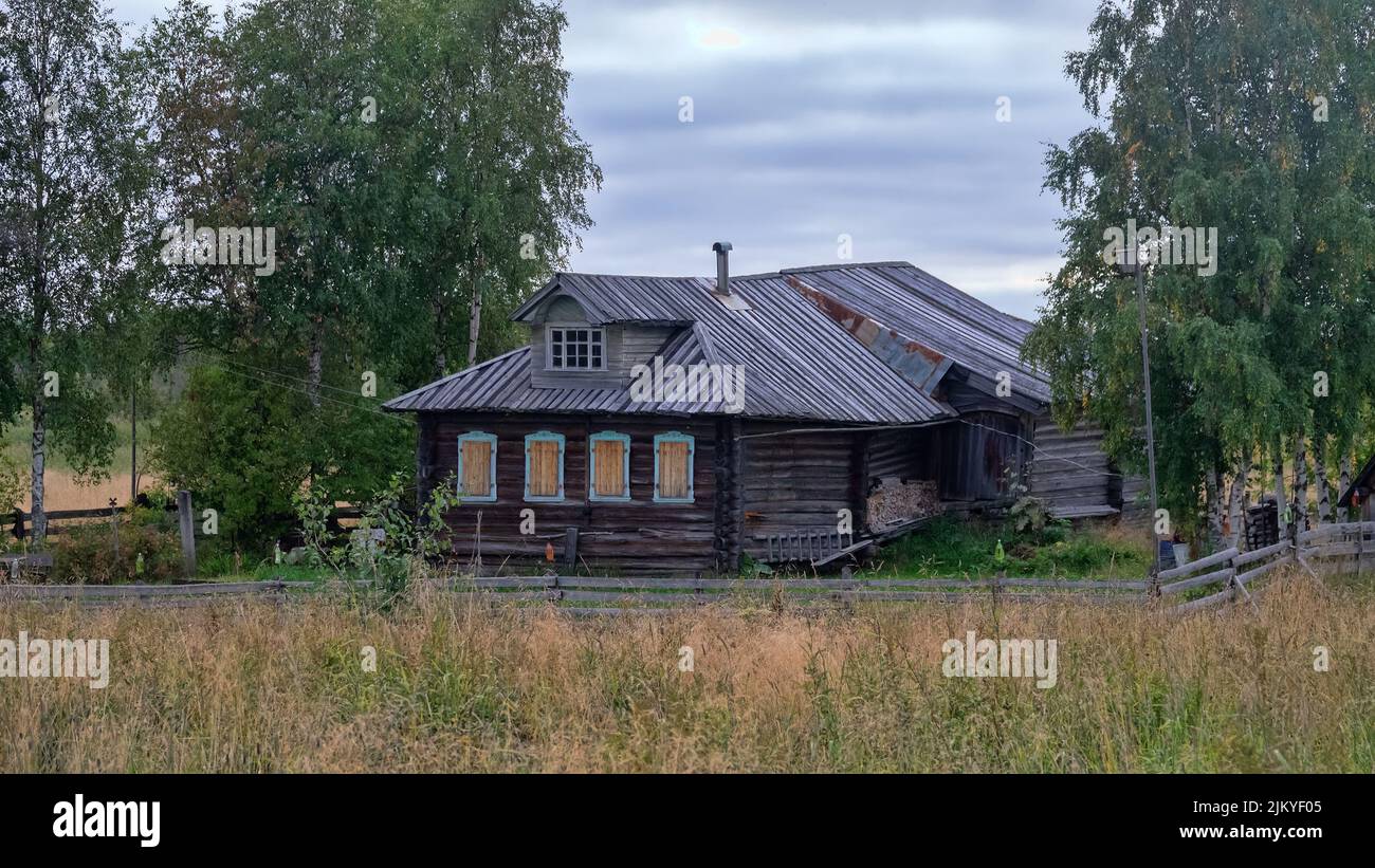 Wooden architecture. Old log houses of the 19th century. See the wide covered barnyard behind the house. Arkhangelsk near-polar regions. Russia Stock Photo