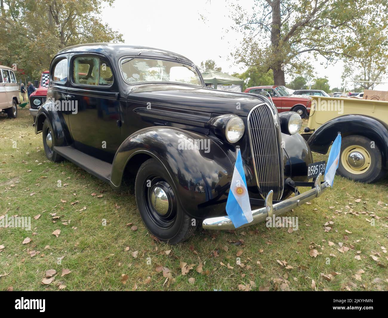 Chascomus, Argentina - Apr 9, 2022: Old black Plymouth two door fastback sedan circa 1937 parked in the countryside. Nature grass and trees background Stock Photo
