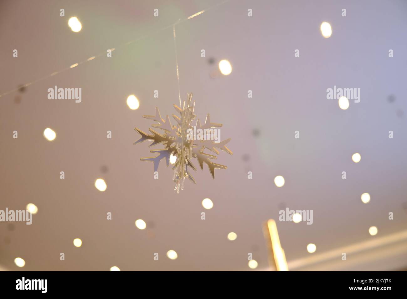 A beautiful snowflake decoration for Christmas hanging on a blurred background Stock Photo