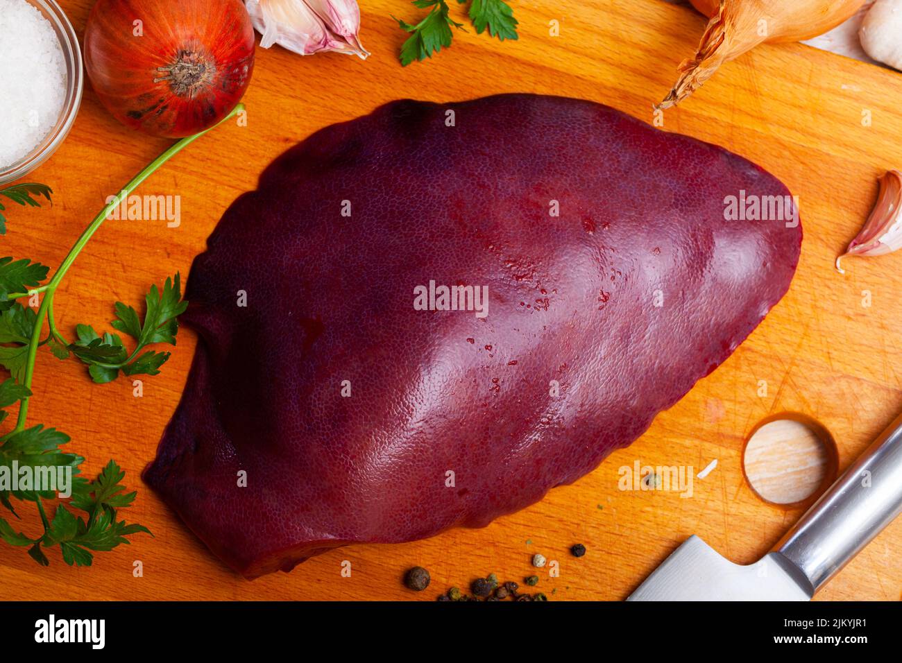 Raw pork liver on wooden surface with garlic and greens Stock Photo Alamy