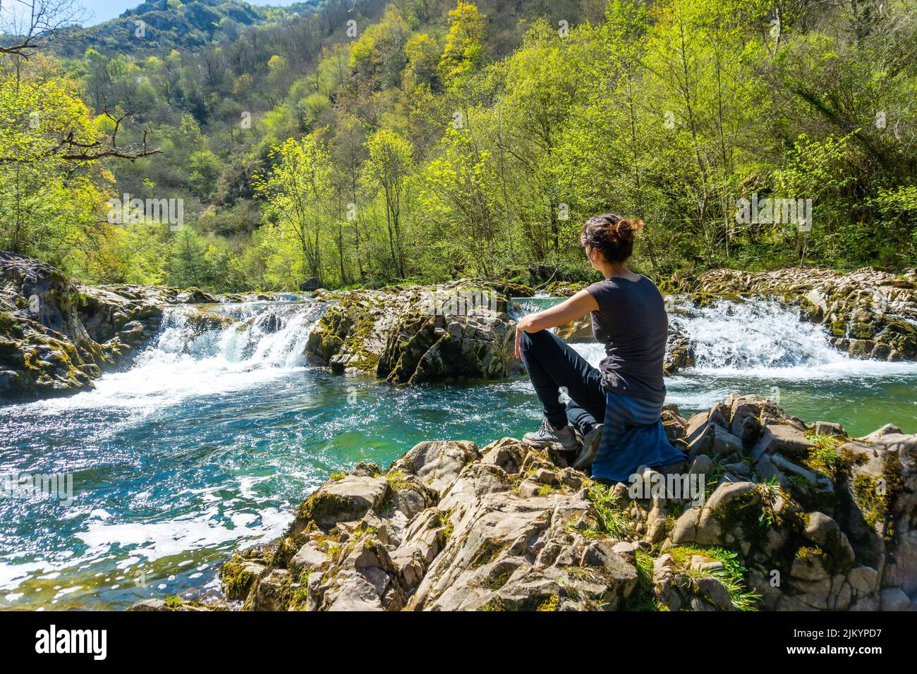 A young woman sitting on the Sella river between the Tornin a la Olla