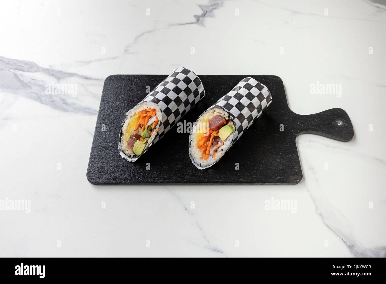 https://c8.alamy.com/comp/2JKYWCR/a-closeup-shot-of-a-sushi-roll-in-black-and-white-wrapper-on-a-dark-board-2JKYWCR.jpg
