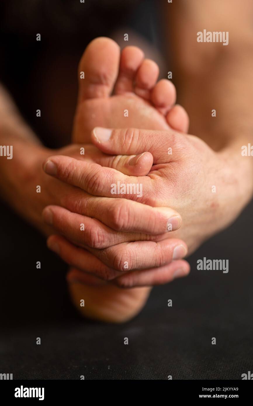 A closeup of a yoga exercise with a hand holding foot Stock Photo