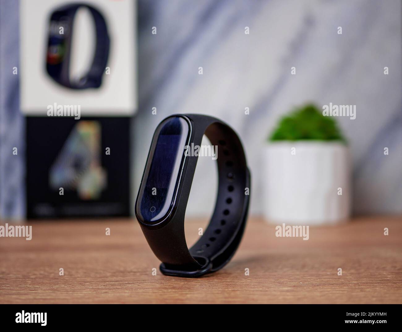 A closeup of a black smart fitness bracelet on a table Stock Photo