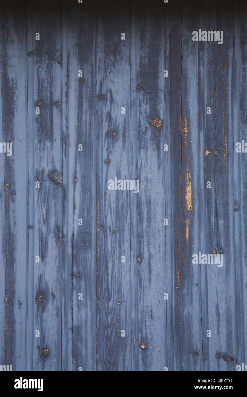 Closeup of weathered wood plank siding on the side of a storage shed