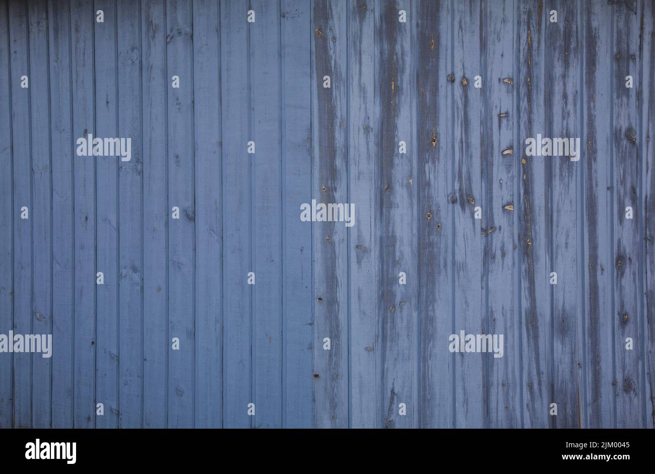 Closeup of weathered wood plank siding on the side of a storage shed