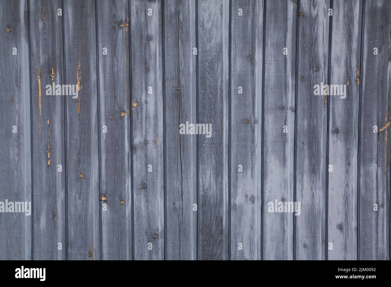 Closeup of weathered wood plank siding on the side of a storage shed