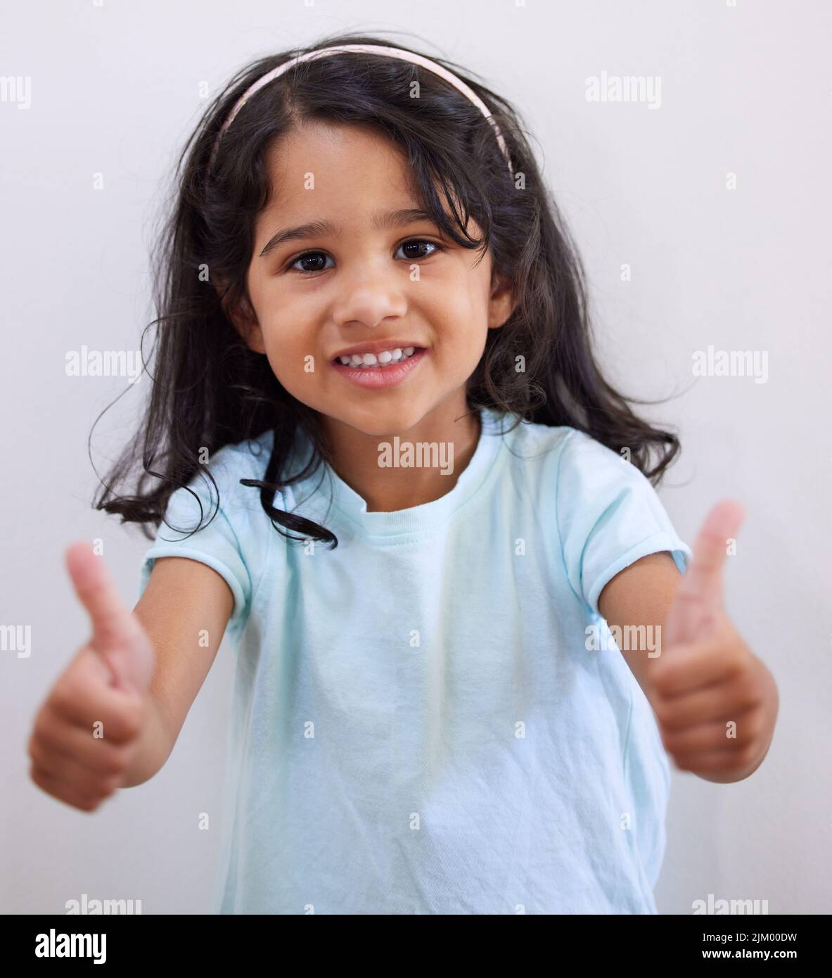 Are you good. an adorable little girl showing thumbs up while posing