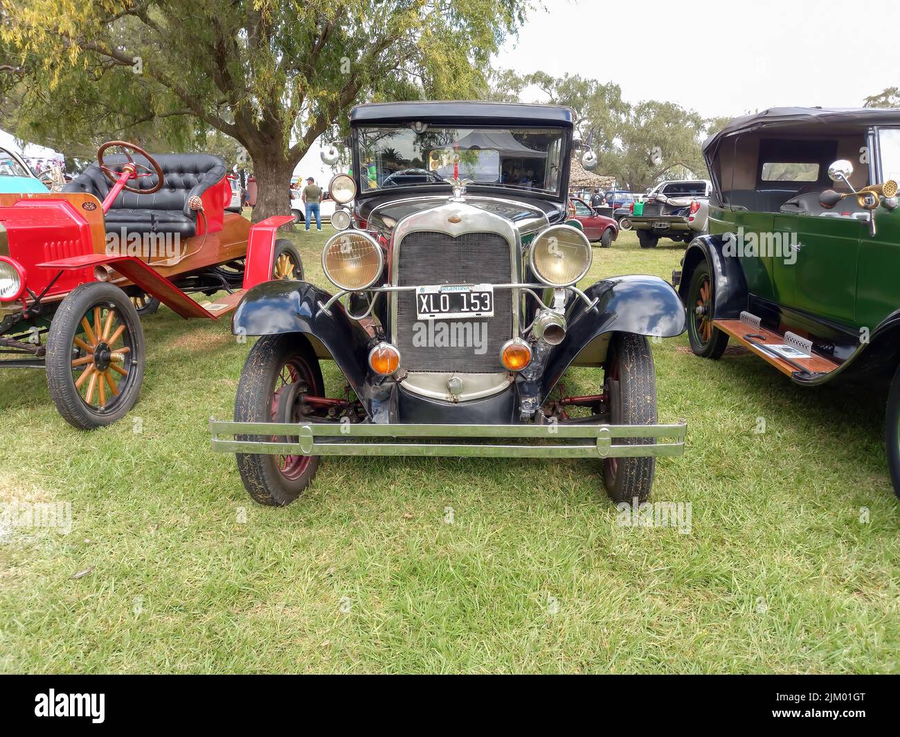 Chascomus, Argentina - Apr 9, 2022: Old black Ford Model A Fordor sedan 1928 - 1931. Front view. Nature green grass and trees background. Classic car Stock Photo
