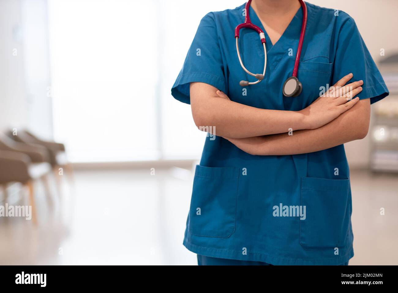 unrecognizable doctor wearing surgery clothes and arm crossed with