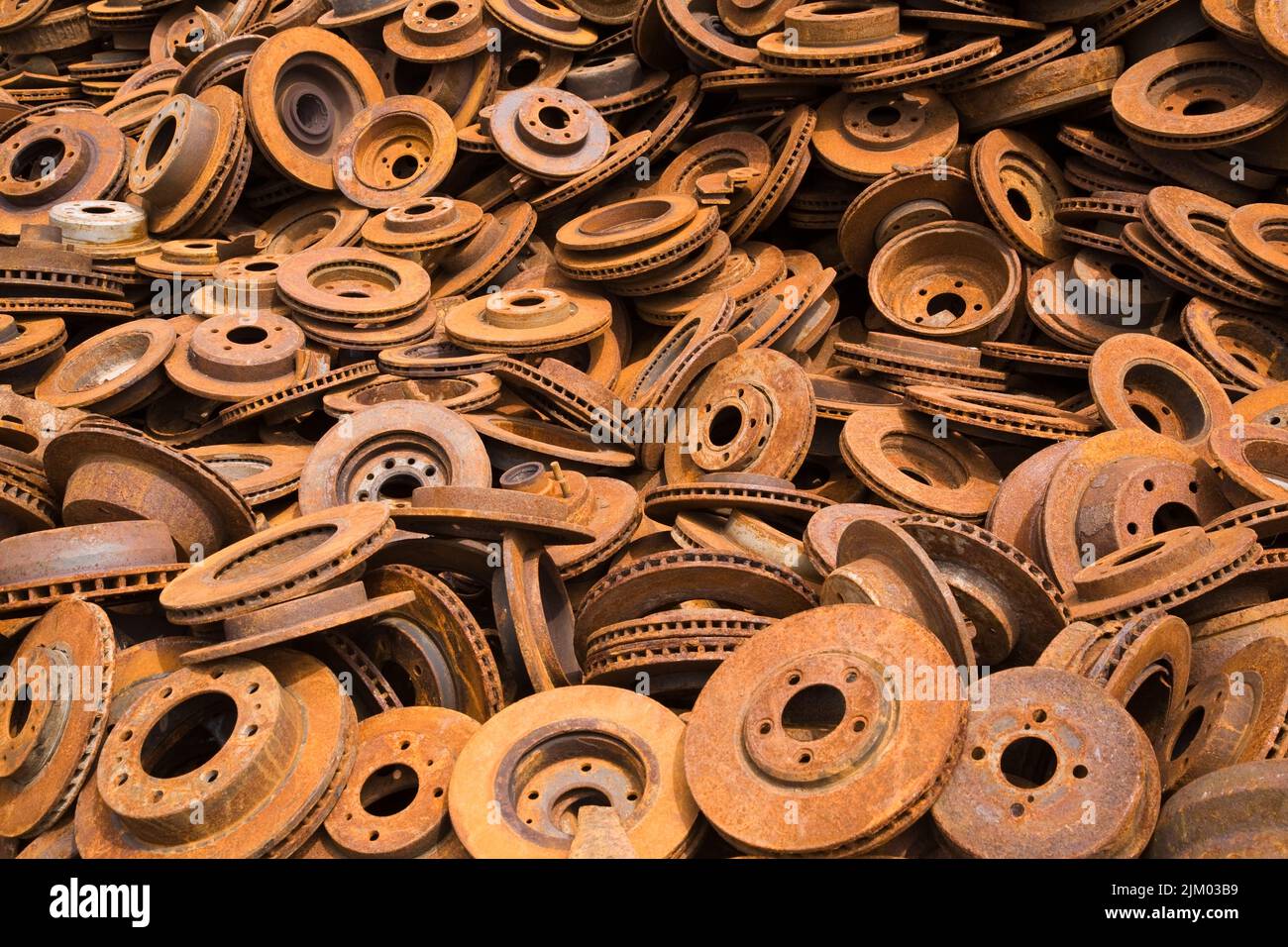 Assorted rusted ferous metal disc and drum brakes at scrap metal