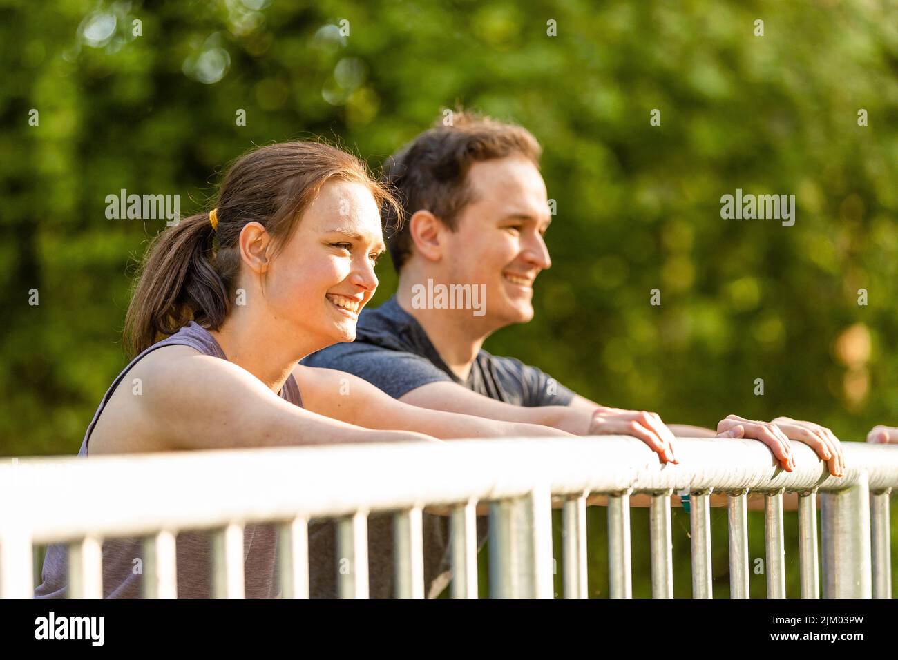 Young woman and man doing stretching exercises in nature Stock Photo ...