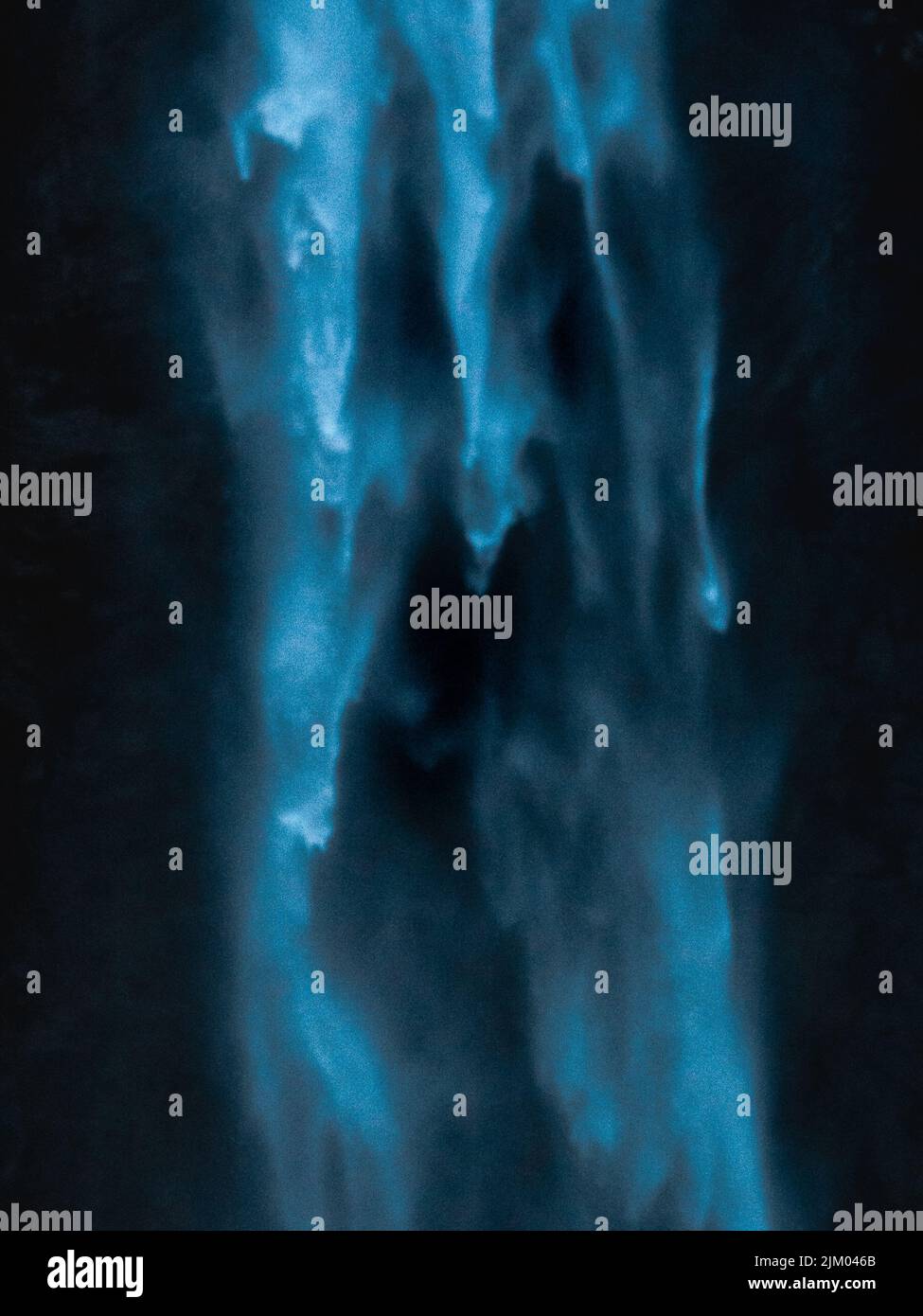 A vertical shot of the motion of a waterfall falling heavily from a ...