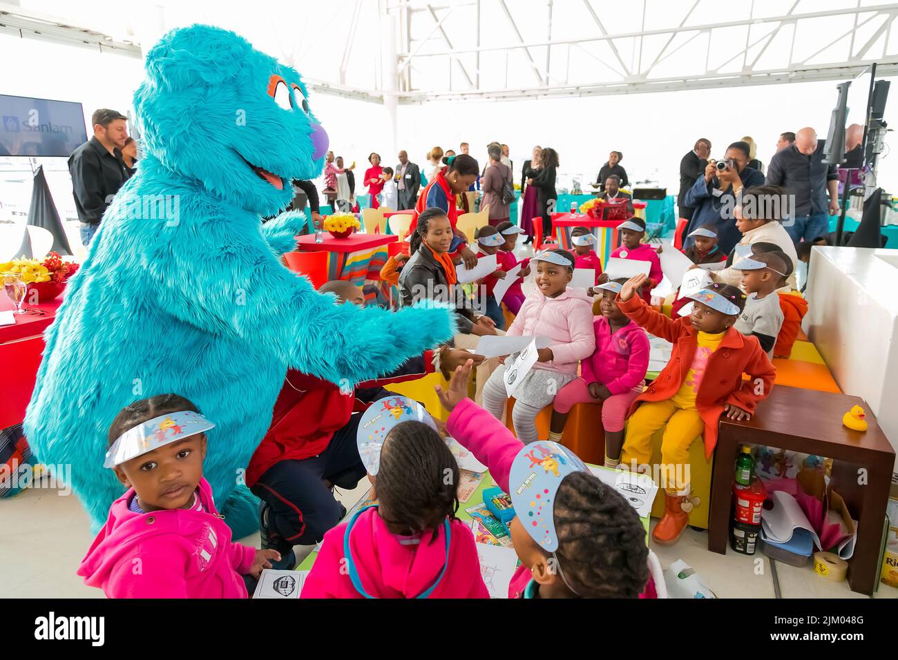 A view of African kids interacting with a person in a fluffy animal suit in Johannesburg,South Africa Stock Photo