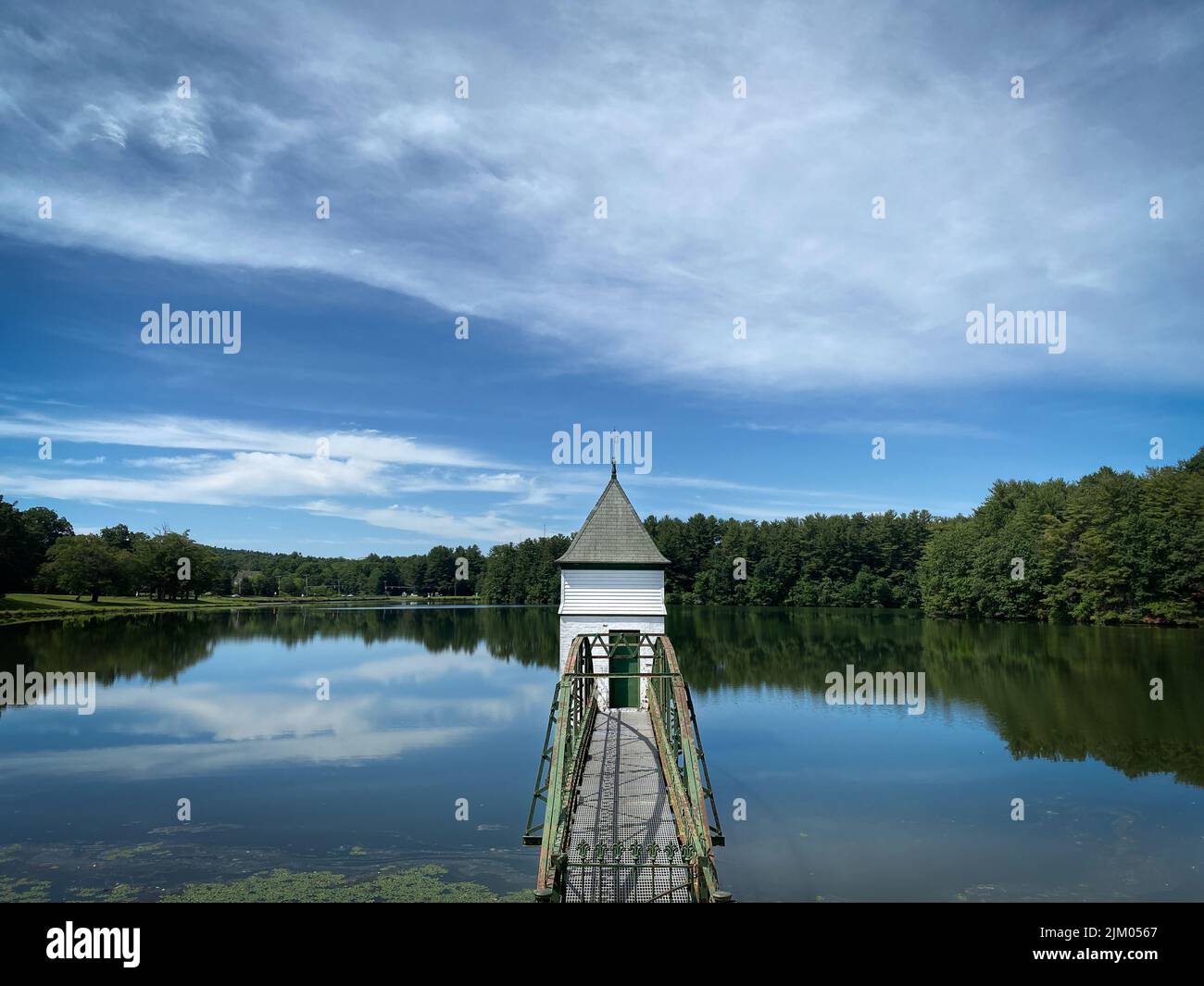 A Gatehouse Bridge in West Hartford Reservoir surrounded by water and trees, Connecticut, USA Stock Photo