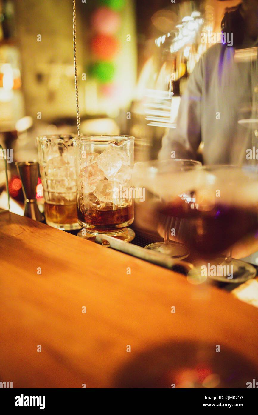 A vertical shot of iced alcoholic drinks in large glass cups in the bar