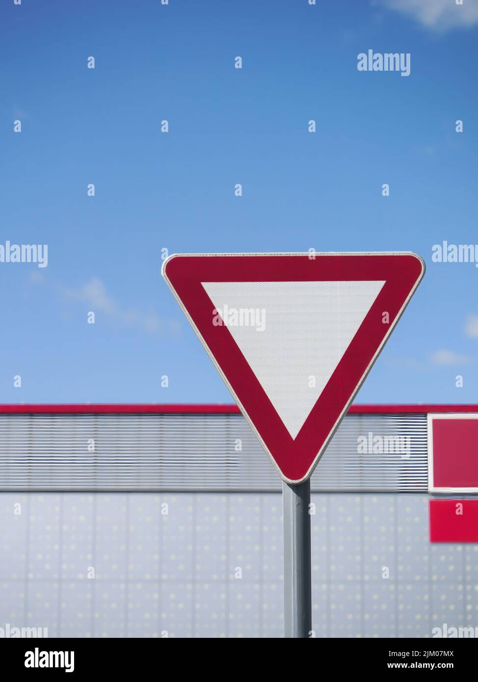 A vertical shot of a red white yield sign on a pole Stock Photo
